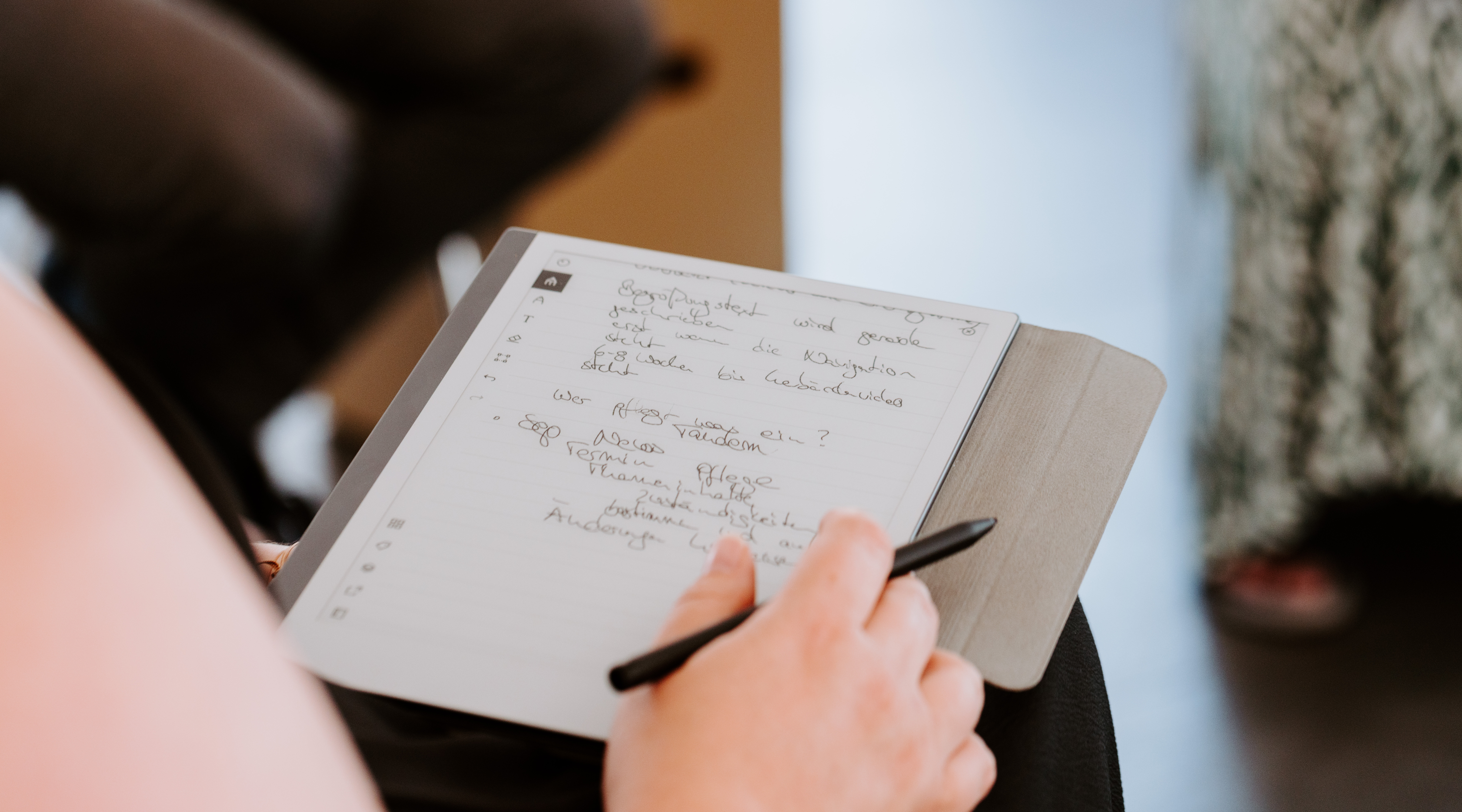 Eine Hand schreibt etwas in ein Notizbuch